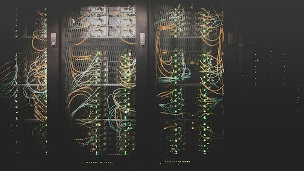 Rows of network cables plugged into server racks in a data center
